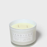 Vanilla-scented candle in frosted glass with cream wax and 'SAND+FOG' label