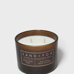 Scented candle in dark brown glass jar with two wicks and Sand+Fog label