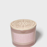 Top view of pink Sand + Fog scented candle jar with embossed swirl lid