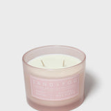 Pink glass jar scented candle with white wax and Sand + Fog label