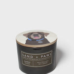 Sand + Paws scented candle in black jar with dog graphic lid and label