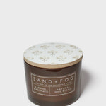 Dark brown scented candle in jar with floral lid, SAN D+FOG label