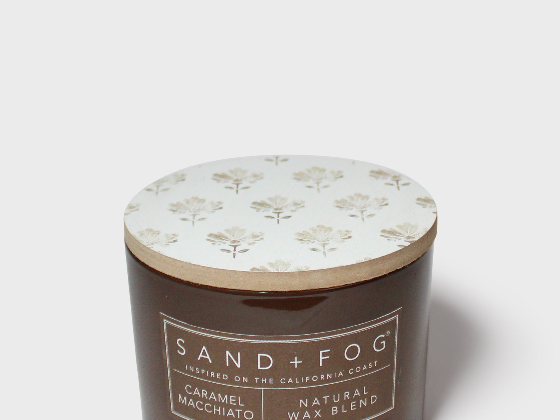 Dark brown scented candle in jar with floral lid, SAN D+FOG label