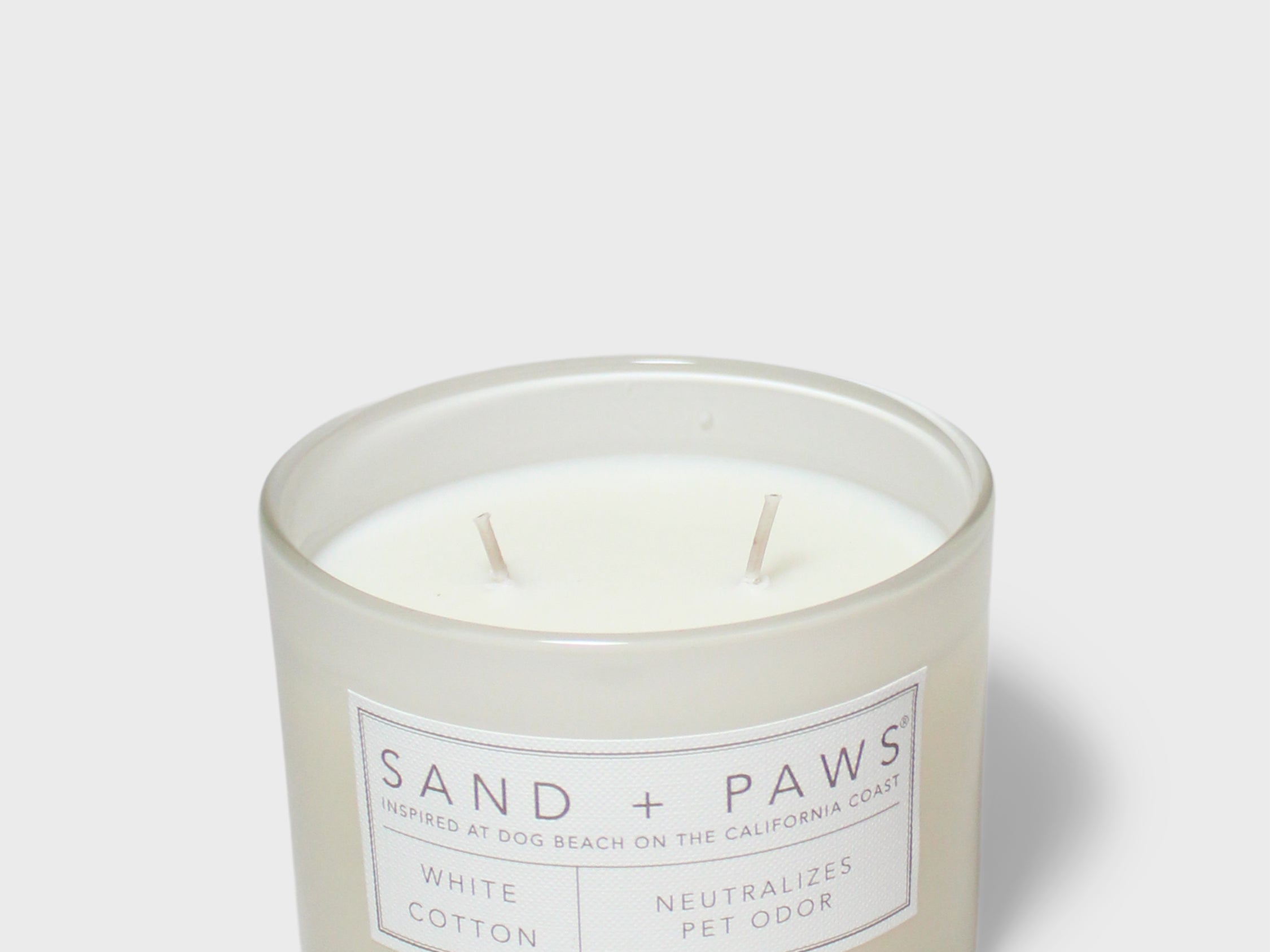 Scented candle jar with white cotton scent label and two wicks