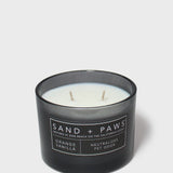 Orange vanilla scented candle with two wicks; dog label on dark jar