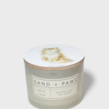 White linen scented candle in frosted glass jar with Sand + Paws label