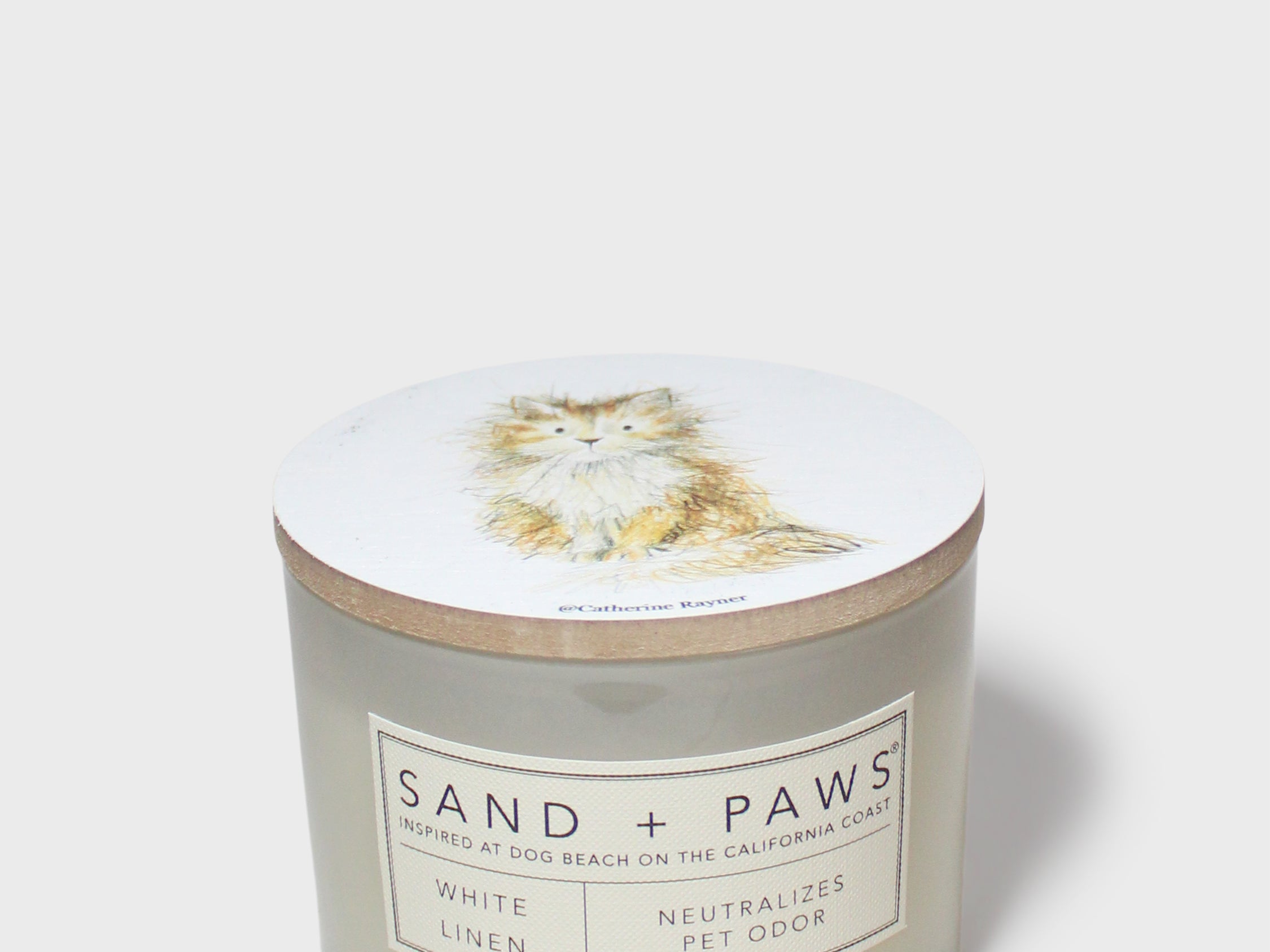 White linen scented candle in frosted glass jar with Sand + Paws label
