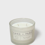 White scented jar candle with two wicks and Sand + Paws label