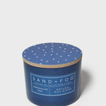 Blue scented candle in round glass jar, speckled lid, printed label with natural wax blend