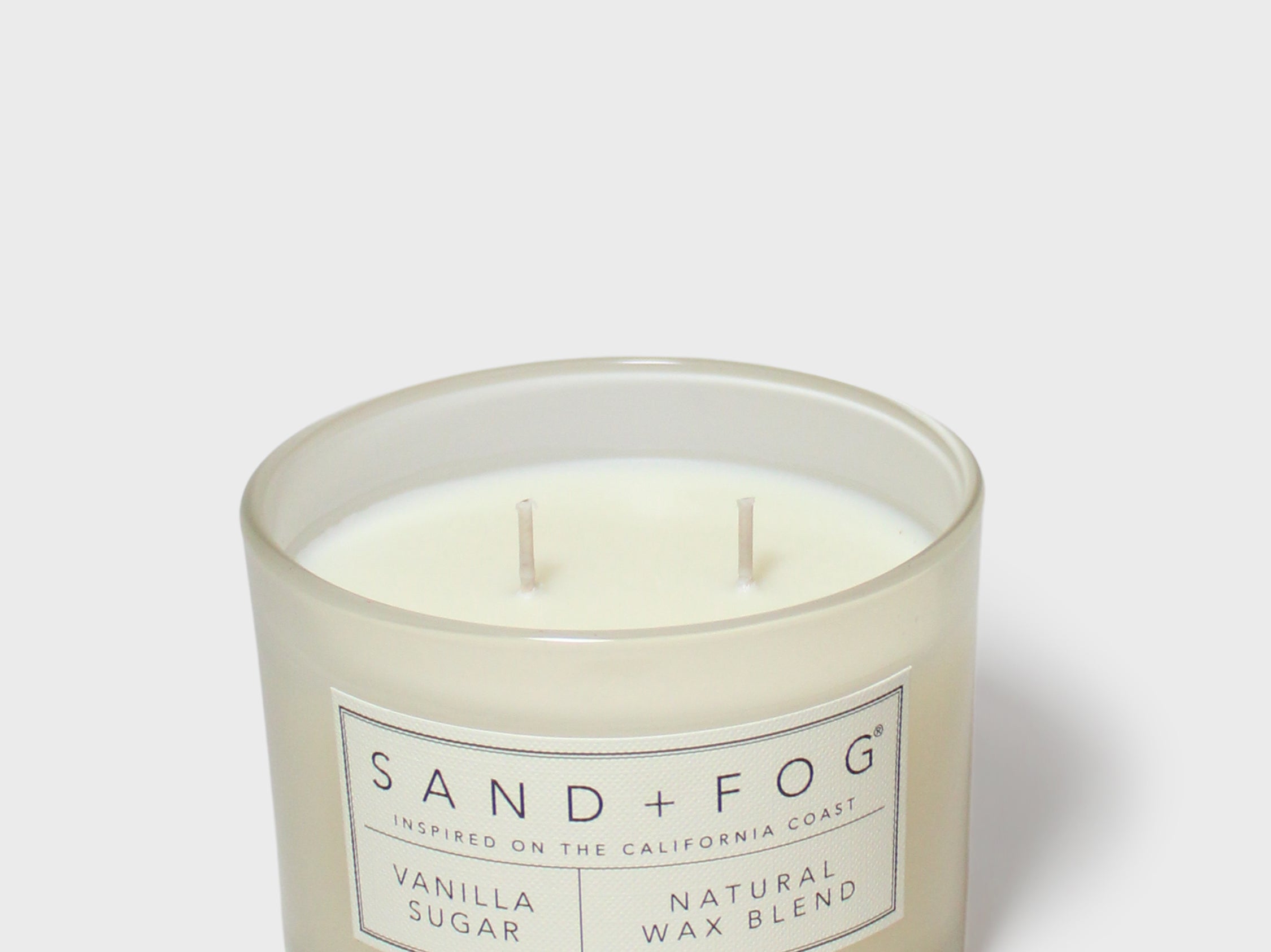 Vanilla-sugar scented candle in clear glass jar with two wicks and label