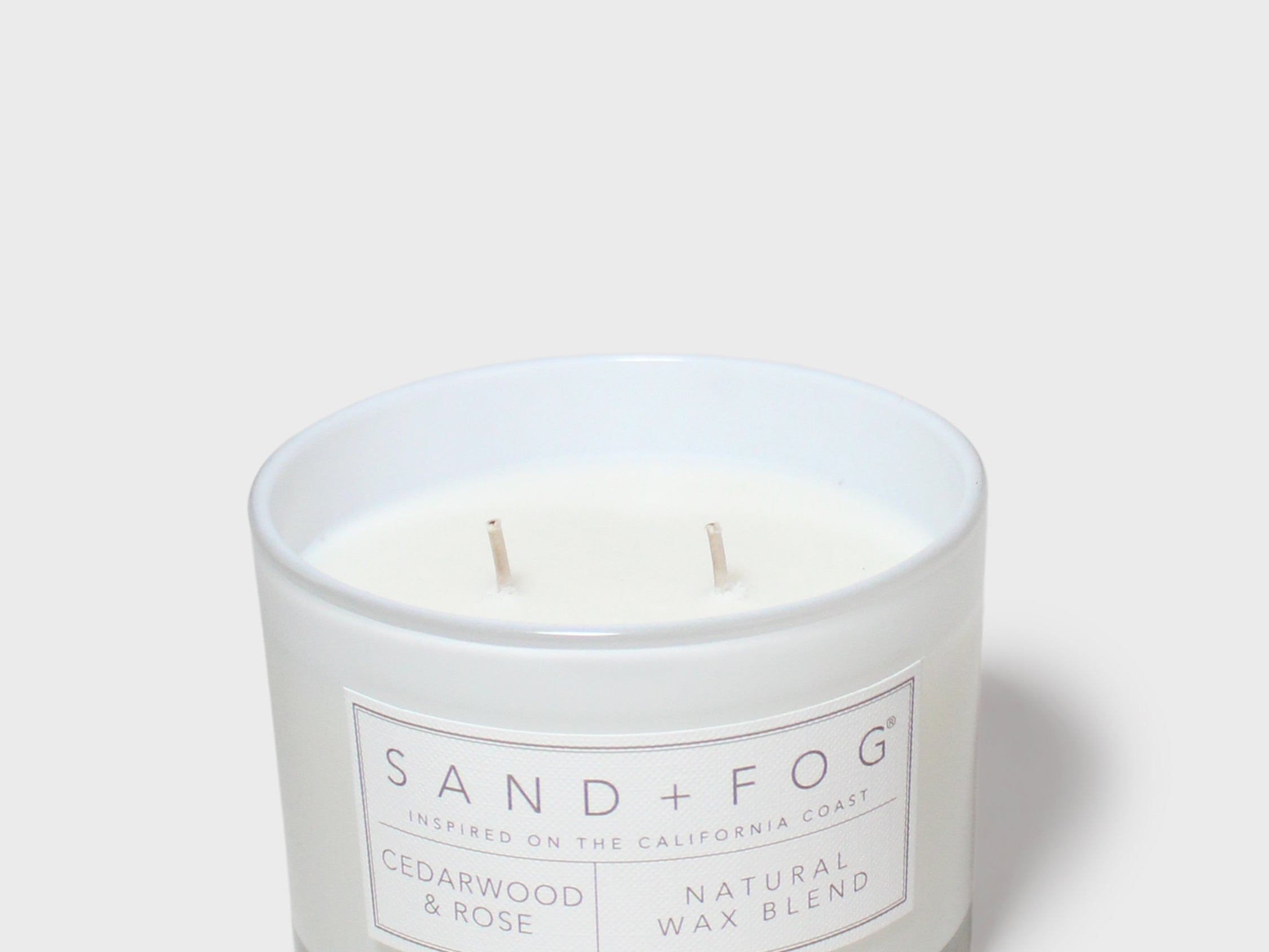 Scented candle in white glass jar with label; cedarwood & rose; two wicks