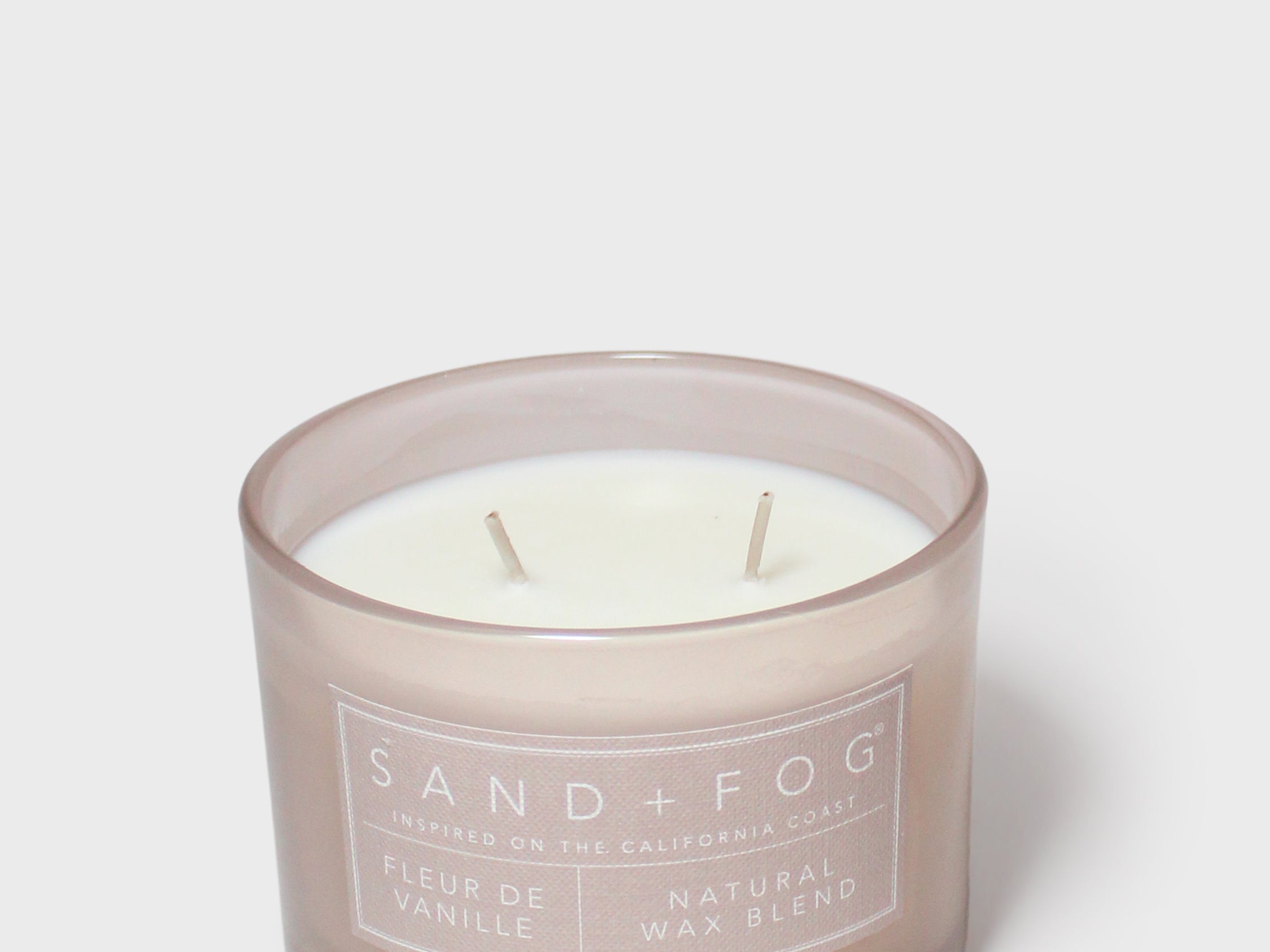 Scented candle in frosted glass jar with two wicks and Vanilla label