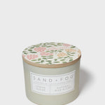 Sage green scented candle jar with botanical lid and label