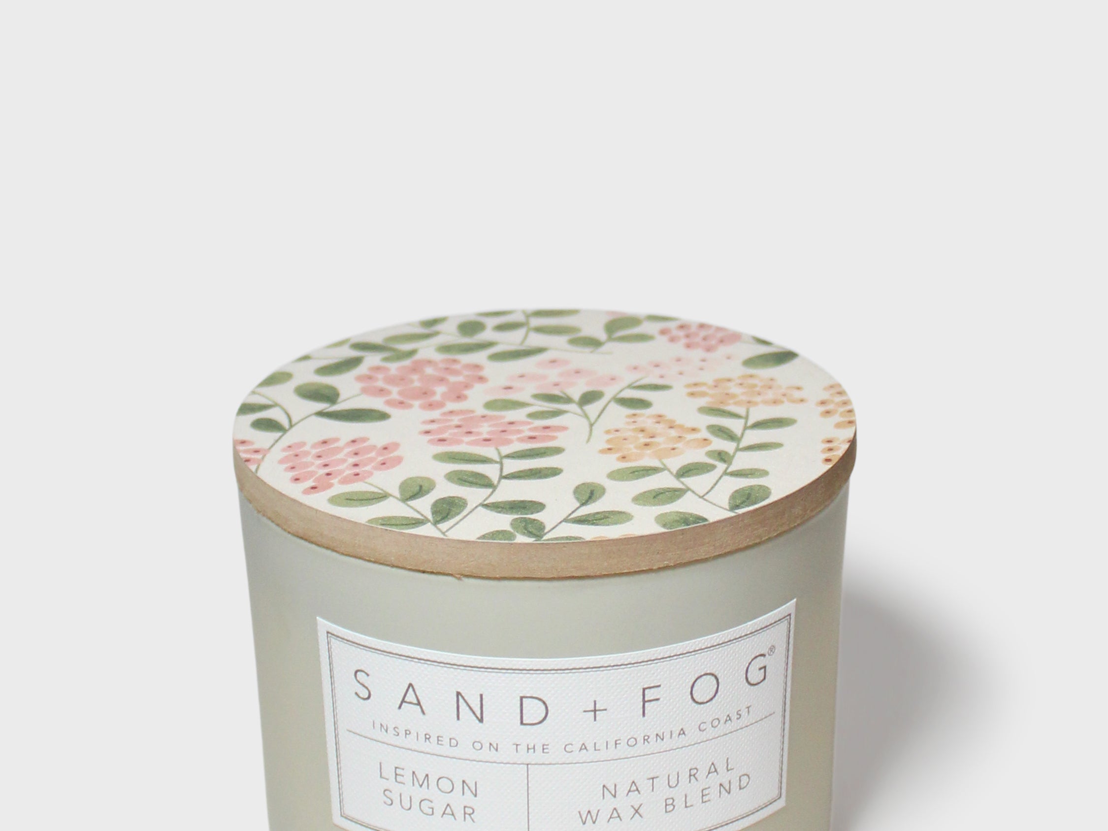 Sage green scented candle jar with botanical lid and label