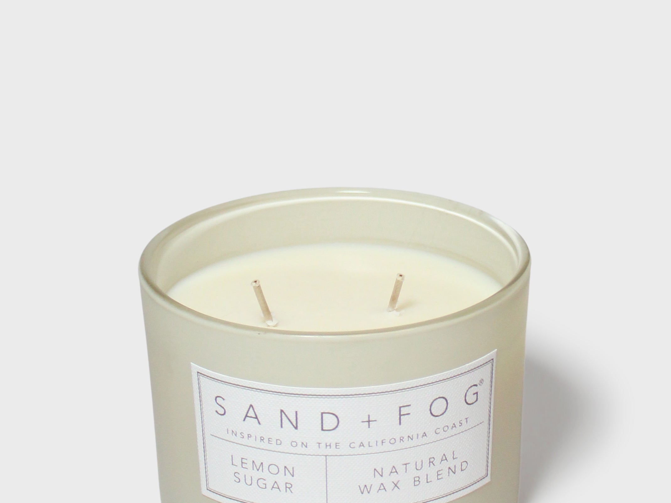 Glass jar scented candle with off-white wax, two wicks, 'Lemon Sugar' label