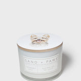 Sand + Paws scented candle in white glass jar with label and cream lid topper