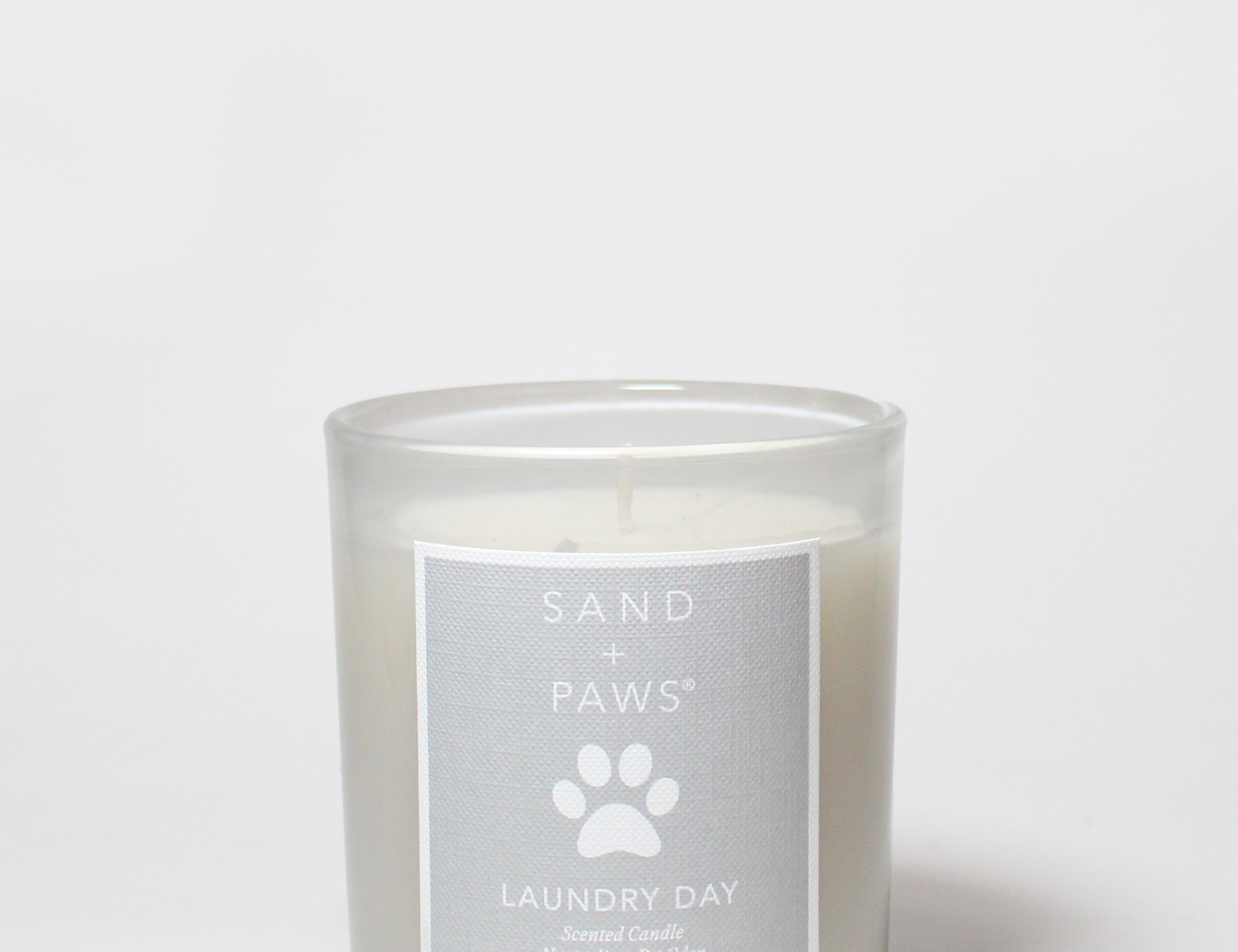10 oz scented candle in clear glass jar with label and visible wick at top