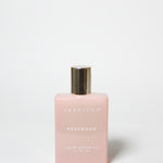 Pink perfume bottle with gold cap on a white background