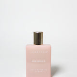 Pink perfume bottle with gold cap on a white background