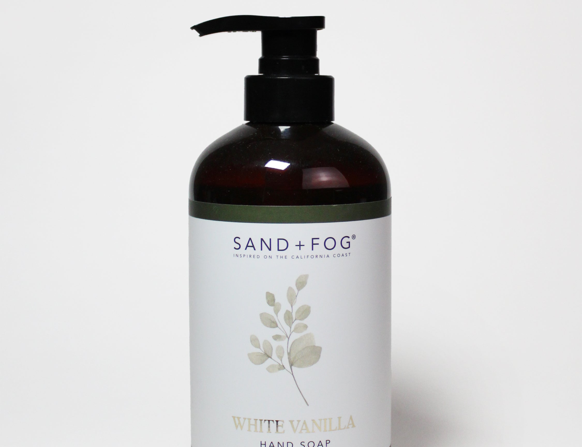 Amber liquid hand soap bottle with black pump, SAND+FOG White Vanilla label