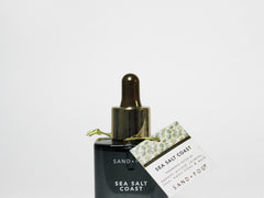 SAND+FOG Sea Salt Coast perfume oil bottle with gold dropper and label card