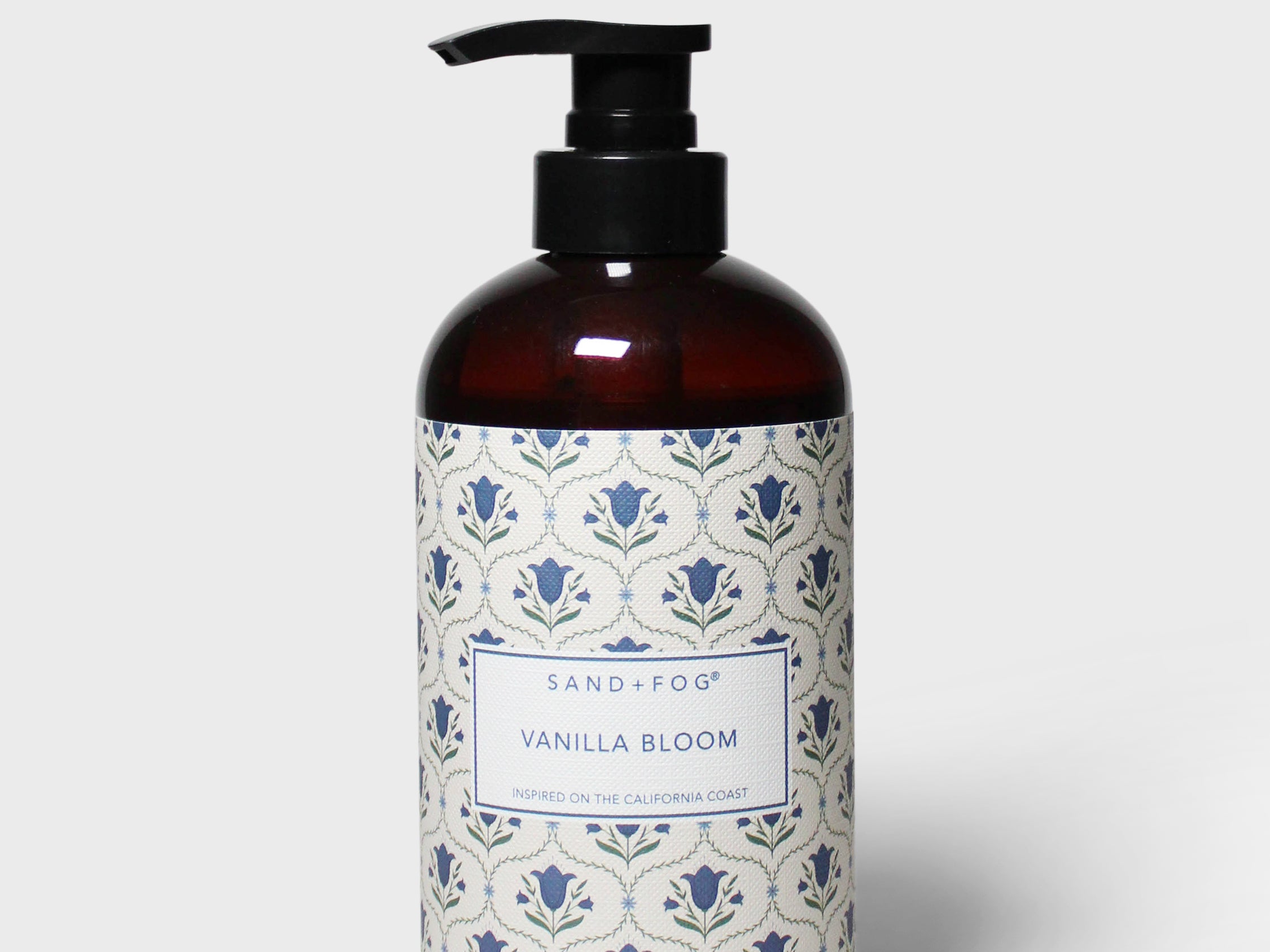 Amber liquid hand soap bottle with black pump and blue floral label