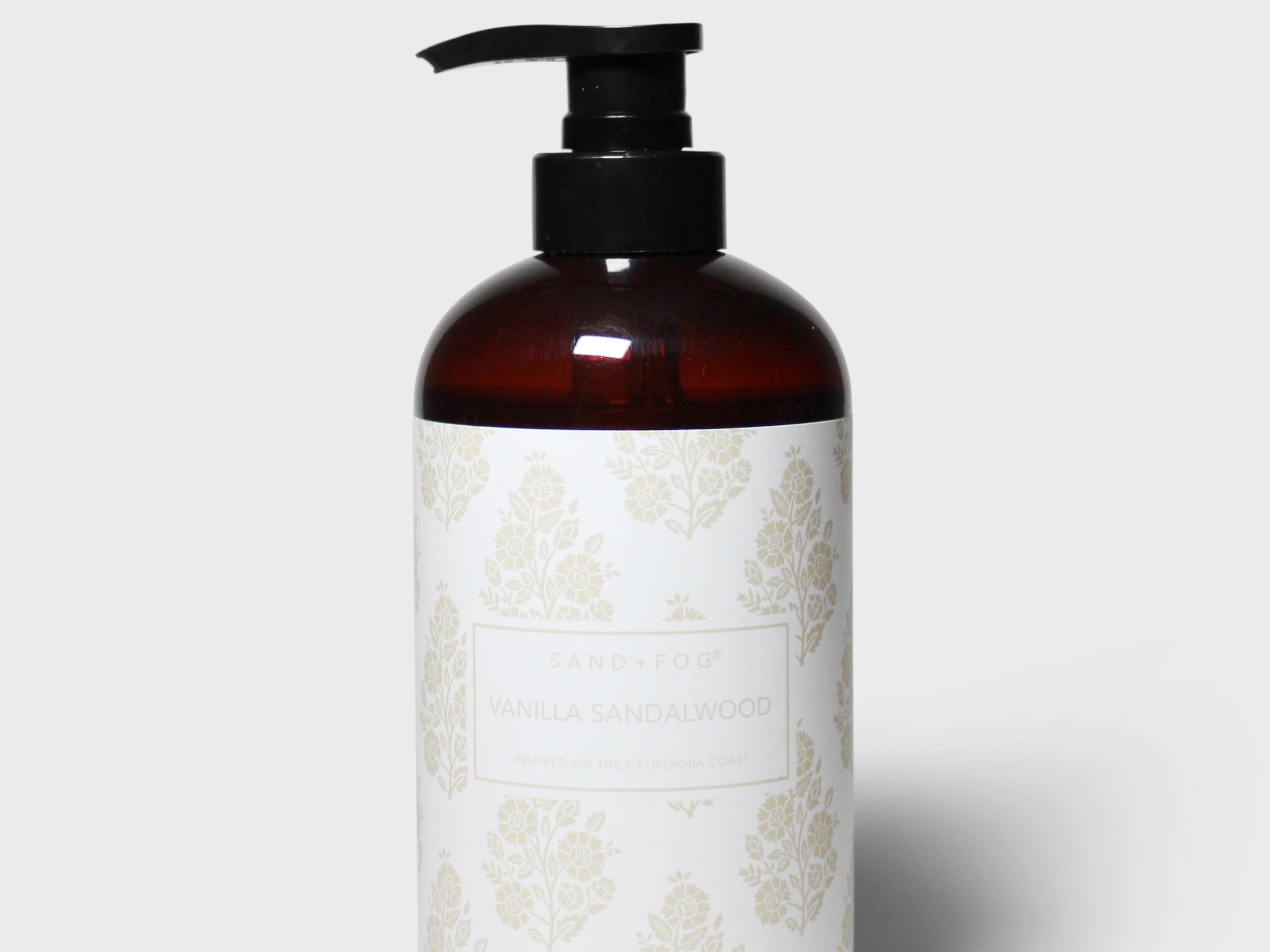 Liquid hand soap bottle with black pump, amber bottle and cream floral label