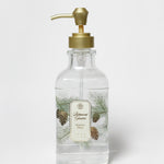 Clear liquid hand soap bottle with gold pump and pine tree label