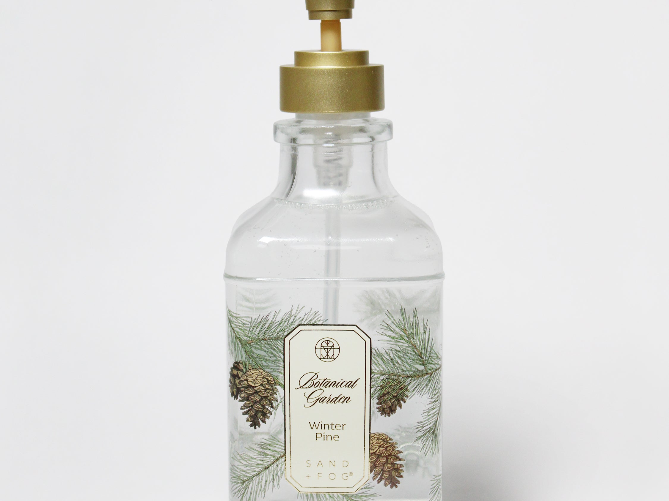 Clear liquid hand soap bottle with gold pump and pine tree label