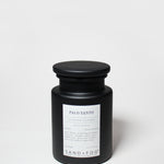 Black scented candle in frosted glass jar with Palo Santo label and black lid