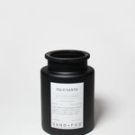 Black jar candle with Palo Santo label, centered on front, and black screw-top lid
