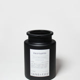 Black jar candle with Palo Santo label, centered on front, and black screw-top lid