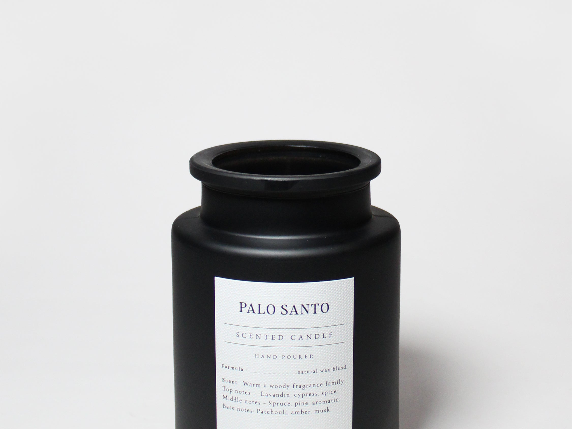 Black jar candle with Palo Santo label, centered on front, and black screw-top lid