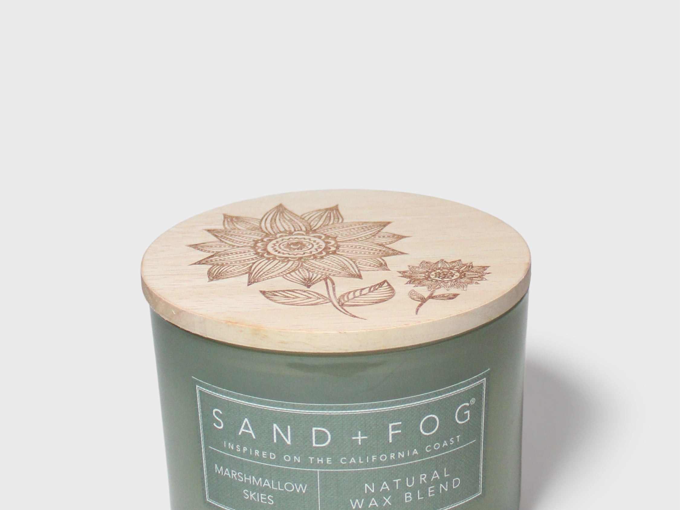 Green glass jar scented candle with botanical-printed cream lid, 12 oz