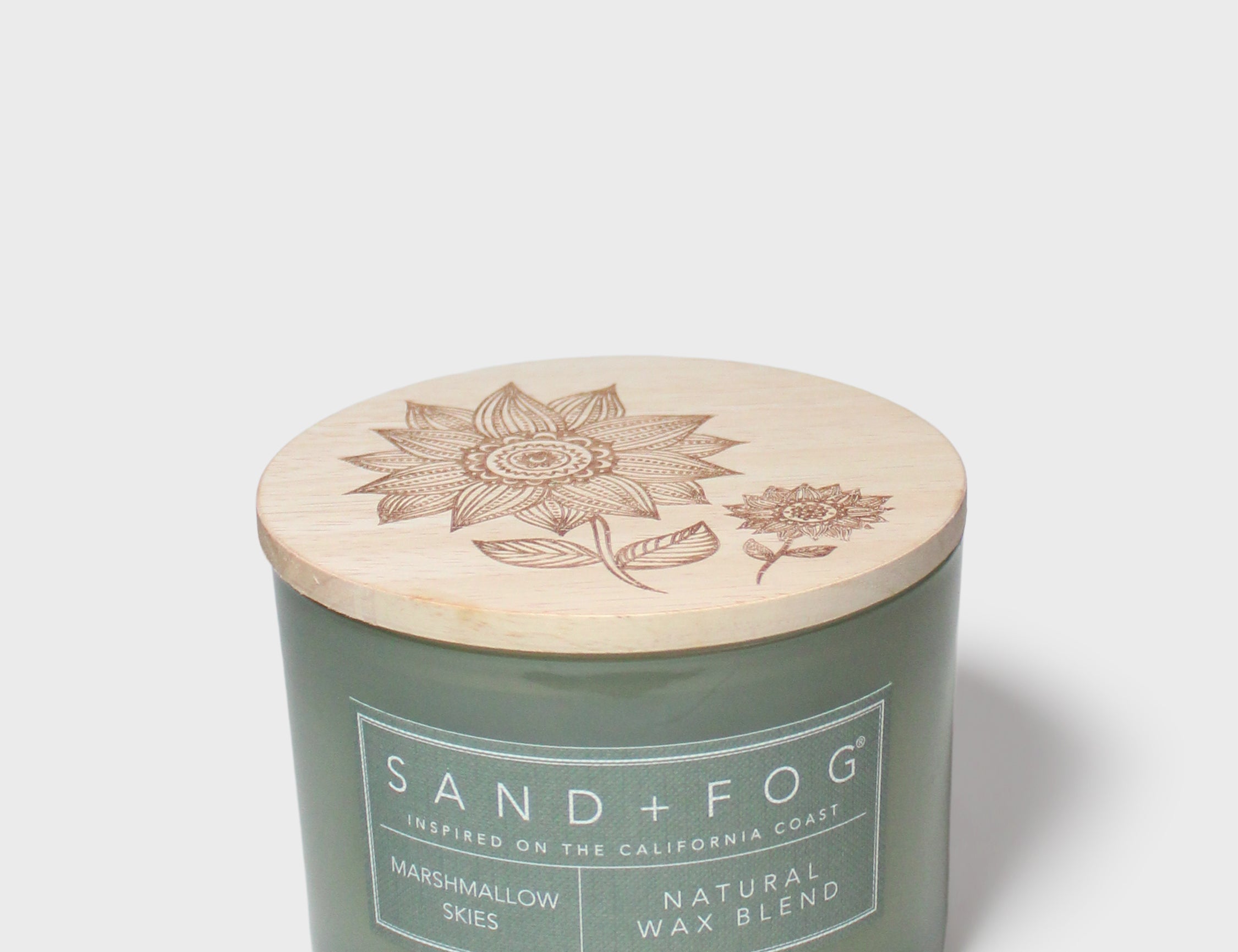 Green glass jar scented candle with botanical-printed cream lid, 12 oz
