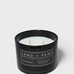 Sand + Paws teakwood scented candle in black glass jar with white wax and wick