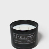Sand + Paws teakwood scented candle in black glass jar with white wax and wick