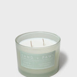 Sage green scented candle in glass jar with two visible wicks and label