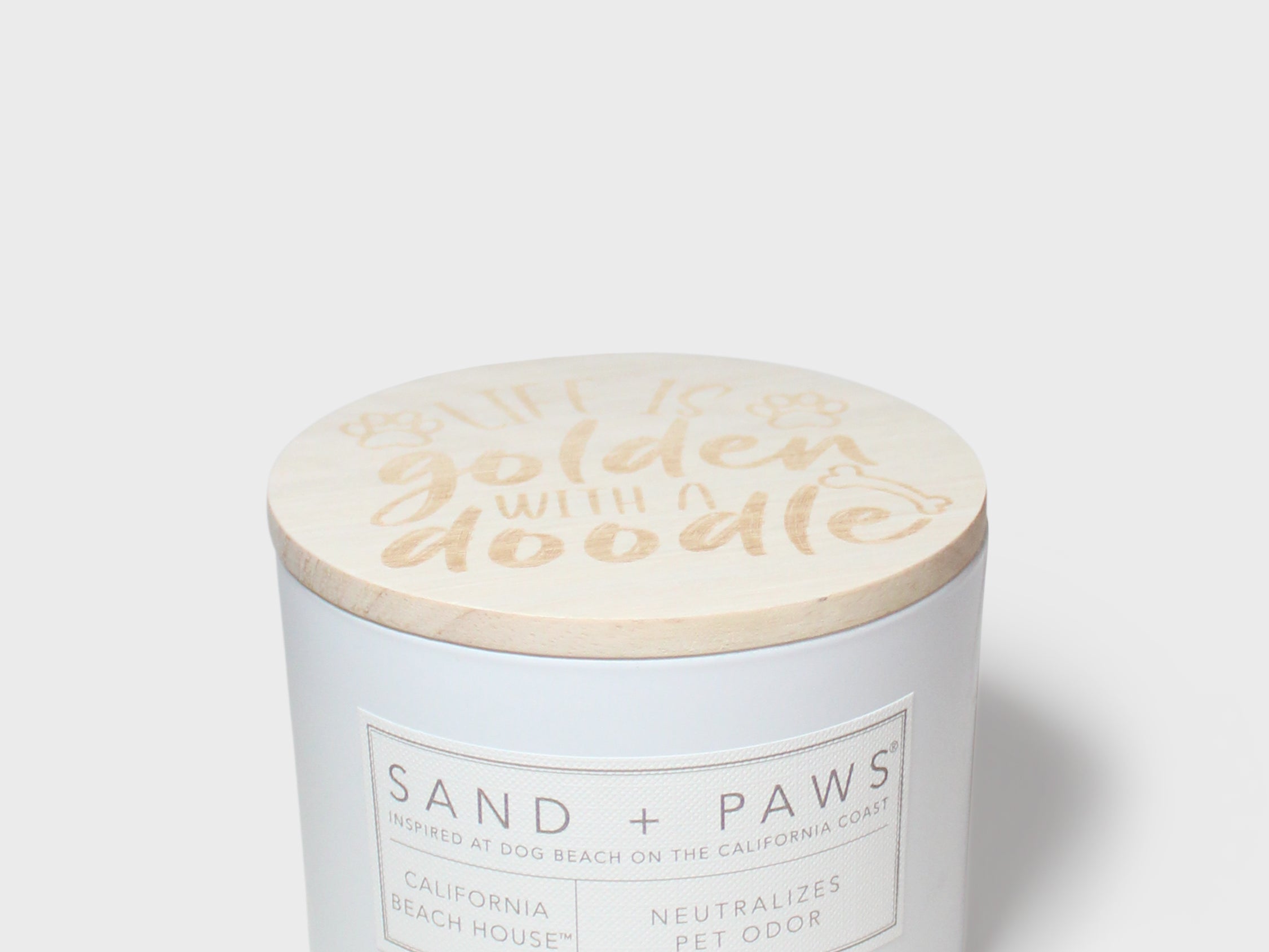 12 oz scented candle with 'golden water' lid and Sand + Paws label