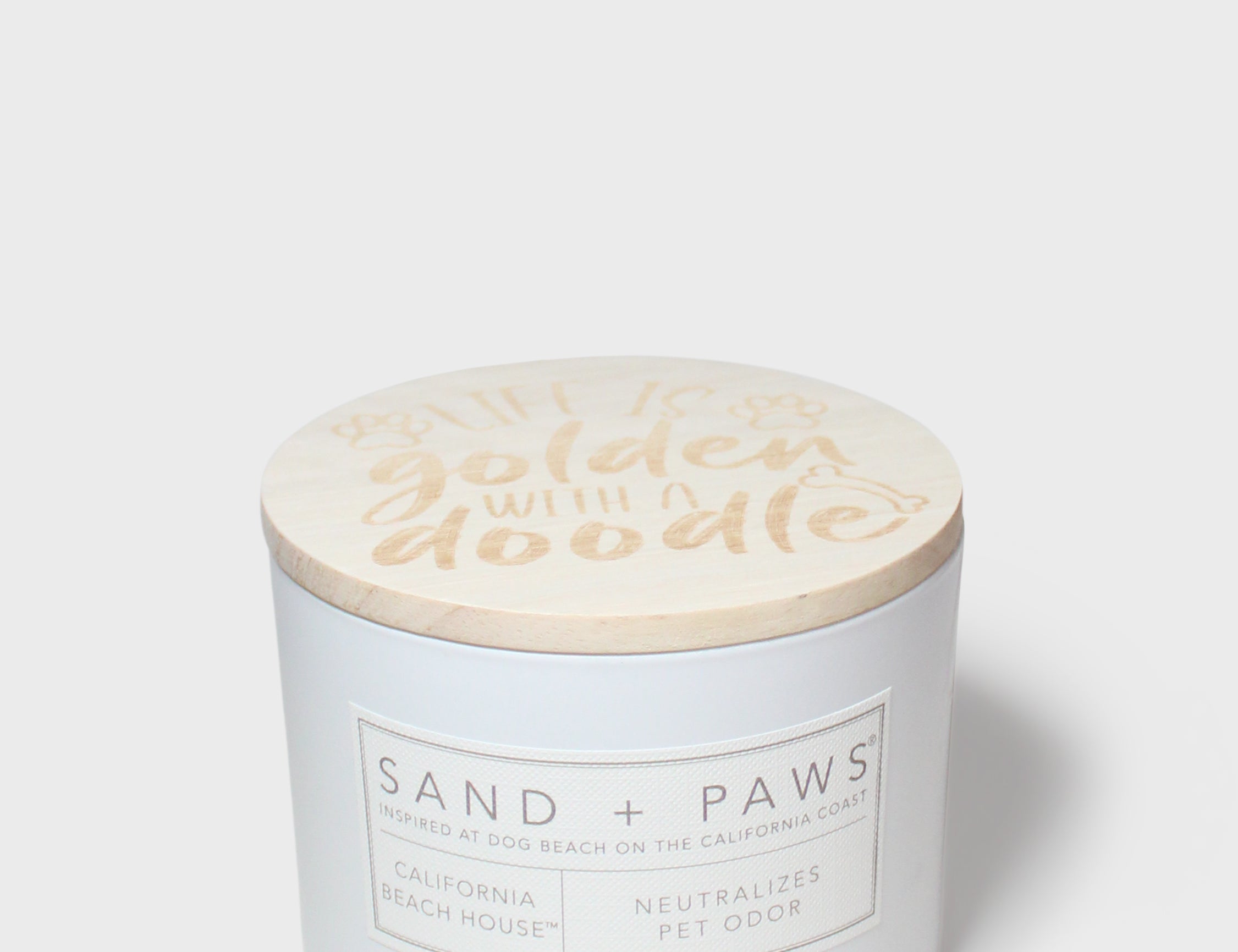 12 oz scented candle with 'golden water' lid and Sand + Paws label