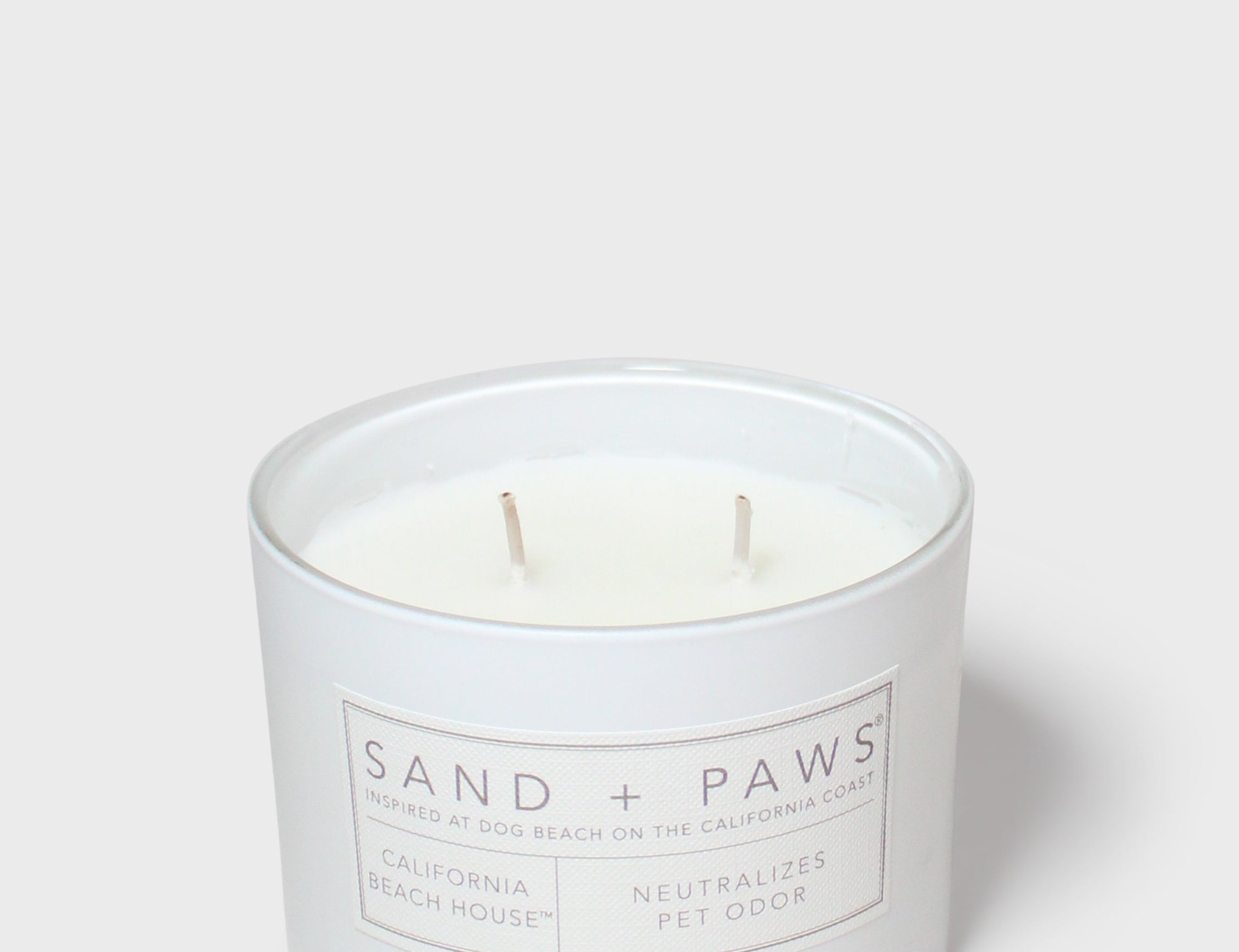 Sand + Paws scented candle in white glass jar with two wicks