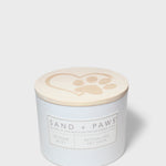 Sand + Paws scented candle with lid showing paw-print heart icon