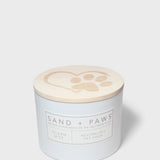 Sand + Paws scented candle with lid showing paw-print heart icon