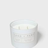 Sand + Paws scented candle in light blue jar with three wicks and label