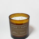 Sand + Paws scented candle in amber glass with label and three wicks