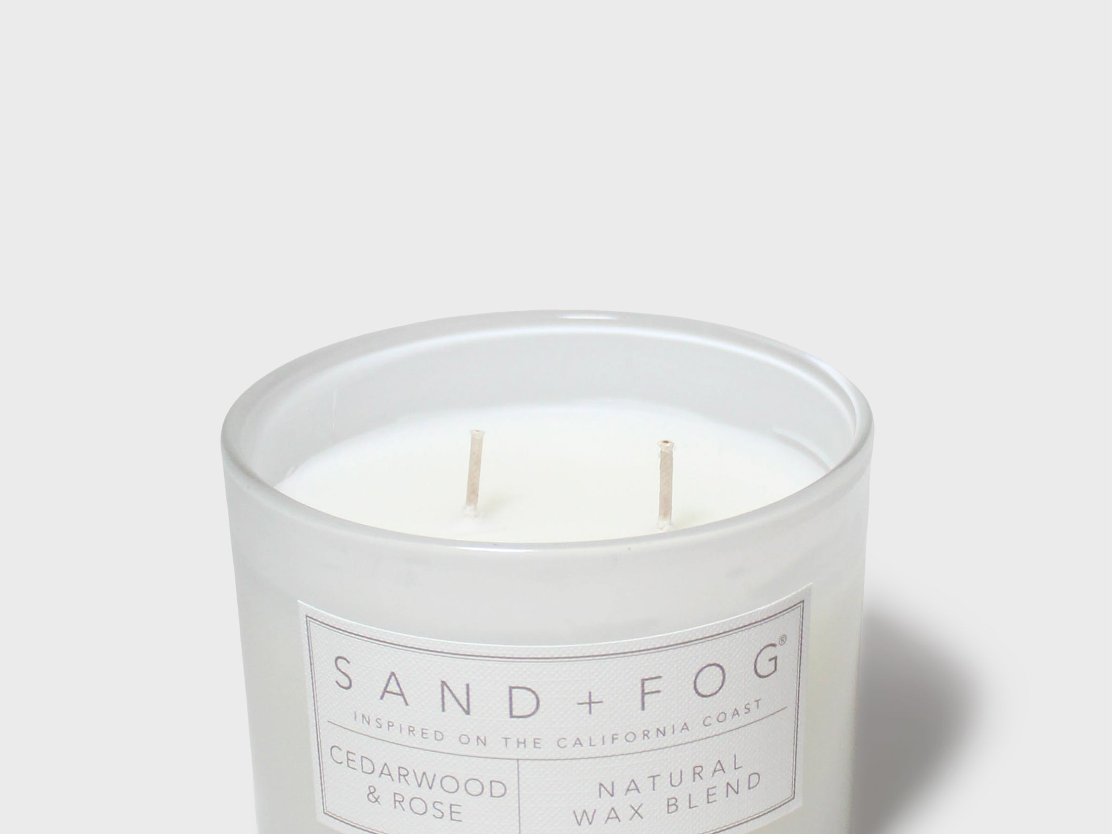 Sand + Fog scented candle jar with two wicks and Cedarwood & Rose label