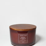 Santal Vanilla scented candle in amber glass jar with wooden lid and label