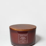 Santal Vanilla scented candle in amber glass jar with wooden lid and label