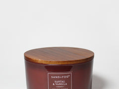 Santal Vanilla scented candle in amber glass jar with wooden lid and label