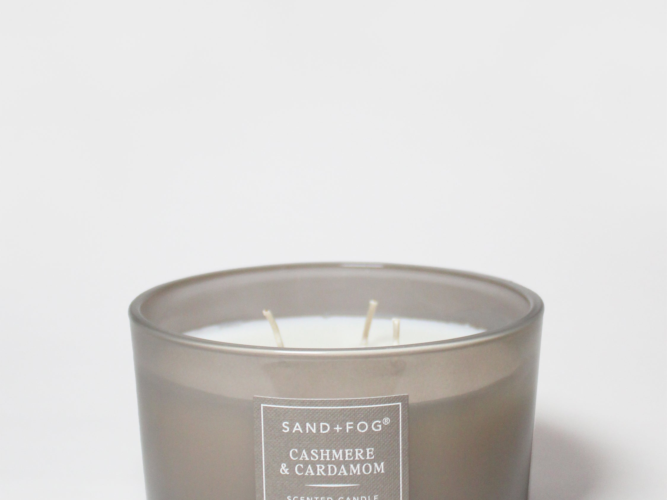 Sand+Fog scented candle in smoky gray glass jar with label and three wicks